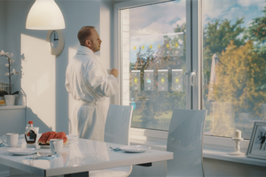  Mann, der am Fenster den Online-Wetterbericht studiert 