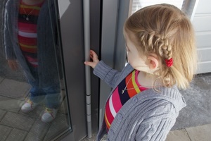  Kind vor einer mit Fingerschutz ausgestatteten Tür 