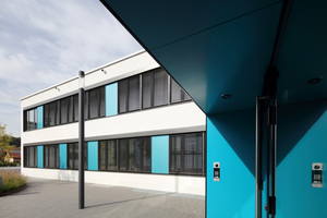  Blaue Fassadentafeln an einem Schulgebäude 