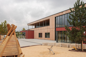  Das zweistöckige Gebäude, das einschließlich der Geschosstrenndecken aus Holz besteht, wurde auf eine teils im Erdreich liegende Tischtennishalle aufgesetzt.  