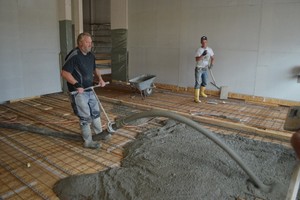  Einbringen von Ortbeton auf eine Balkendecke mit OSB als verlorene Schalung. Oft wird der Holzbau bis Dachkonstruktion fertiggestellt und der Beton am Schluss eingepumpt 