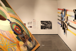  Das etwa 10 x 15 Meter große Werk „Air, fer, eau“ (1937) von Robert Delaunay scheint den Marta-Dom fast zu sprengen. Ihm gegenüber zeigt Angela Fette (*1970, Düsseldorf) auf 25 Metern Länge die Wandmalerei „Musikmaschine“ (2018) mit skulpturalen Elementen 