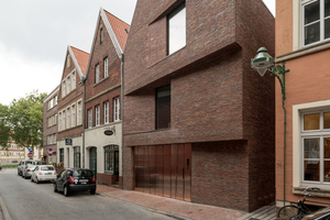  Die strenge, eher verschlossene Straßenansicht wird durch zwei Versprünge in der mit rotbraunem Klinker verkleideten Fassade gestaffelt 