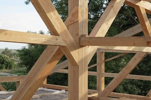  Nachdem das Holzrahmenwerk aufgerichtet worden war, wurden die Kräfte der Verbindungen durch die Kiesbefüllung der Decke auf der Seite der Wohnhalle aktiviert 
