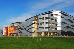  Für die dynamische Gestaltung der Fassade kamen rund 20 000 m² Aluminiumpaneele zum Einsatz eloxiert im Naturton sowie Dunkelblau, verschiedenen Rot-, Orange- und Gold-Nuancen und einer Holzstruktur. Jedes Paneel ist individuell, innerhalb des Musters gibt es keine Wiederholungen 