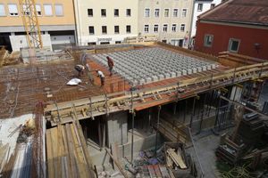  Zwischen dem Gemeindesaal und dem Synagogenraum befindet sich eine Stahlbetonkassettendecke, die wegen der Ostung des Synagogenraums leicht aus dem Grundrissraster verdreht ist. Im Bereich der großen Glasfronten mussten die Lasten der Decke nach oben in die Stahlbetonwandscheiben des Synagogenraums abgetragen werden (s. statisches Raummodell) 