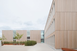  Auf einer kleinen Anhöhe öffnet sich ein  großer Eingangsplatz mit dem dreigeschossigen Schulhaus, das zurzeit aus dem mittleren Haupttrakt und einem Seitenflügel besteht 