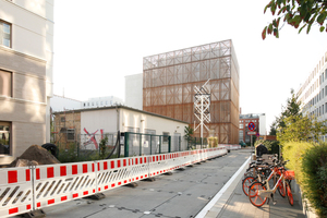  Winkt in den Straßenraum (Zinnowitzer Straße) herüber: der mit Holz verkleidete Bühnenturm der HfS Ernst Busch 