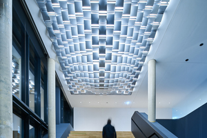  Über der Sitztreppe im Foyer schebt eine 5,5 x 8 m große Licht-skulptur, die sogenannte „Cloud“, die das Aushängeschild für den Leuchtenhersteller darstellt. Sie besteht aus einzelnen Leuchtkacheln 