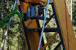  Konstruktion des 34 m hohen, um 15 Grad geneigten Aussichtsturms: Er steht am tiefsten Punkt des Besucherzentrums und ist über den Skywalk erreichbar. Die Konstruktion aus Brettsperrholz und Stahl ist am Fußpunkt in ein Blockfundament eingespannt. Stahlgurte in Verbindung mit Stahlstreben stabilisieren das Brettsperrholz in den hochbelasteten Anschluss- und Eckbereichen. Horizontale Ebenen aus Brettsperrholz steifen die Konstruktion aus 