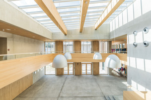  Das zentrale Atrium der Grundschule, das als Versammlungsraum für den gesamten Schulkomplex dient, wird von einem filigranen Glasdach mit vier Reihen Velux Modular Skylights als Stufen-Lichtband-Lösung überspannt. 56 dieser Module wurden eingebaut. Das Glasdach mit integrierter Verschattung und Belüftung wurde innerhalb einer Woche installiert. Alle Elemente sind mit einem innenliegenden, weißen Rollo versehen. Acht Module können zu Lüftungszwecken geöffnet werden, so dass das Glasdach aktiver Bestandteil des Klimakonzepts des Gebäudes ist 