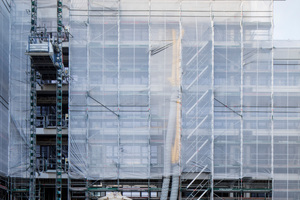  Die geöffnete Fassade, über eine Folie wetterfest eingepackt, zeigt ein Gerüst und Schuttrutschen; hier sieht man auch die Versorgung der Baustelle, die allein im rückwärtigen Bereich des Gebäudekomplexes eingerichtet war (Lastenaufzug u. ä.) 