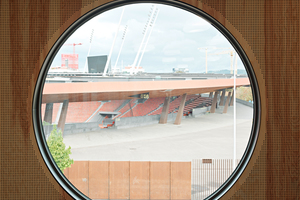  Die Wände und Decken im Aufenthaltsraum sind mit hellem Bauholz und gelbrötlichem Seekieferholz verkleidet. Aus dem runden Fenster blickt man direkt auf das Stadion Letzigrund 