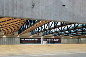  Die Halle mit einer Spannweite von 55 m kommt ohne Stützen in der Nutzfläche aus. Trotz seiner Dimension wirkt das Dach filigran. Schubsteif beplankte Holzelemente bilden die Dachflächen, die fast komplett für die Photovoltaik-Anlage zur Verfügung gestellt werden  