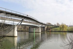  Parallel zur Pont Neuf schwingt die Fußgängerbrücke von Mantes-la-Jolie zur Seine-Insel. Von dort wird es dann in einem späteren Bauabschnitt weitergehen bis nach Limay 