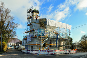  In der ersten Sanierungsphase schützt ein temporäres PERI UP Wetterschutzdach das Kirchenschiff vor Witterungseinflüssen. Die vormontierten LGS Binderelemente wurden dann mit dem Kran gehoben. Besondere Achtsamkeit verlangten dabei die schräg verlaufenden Leitungen auf Dachniveau 