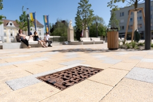  Der Schlossplatz in Bad Vöslau verbindet Grünflächen und Sitzgelegenheiten. Unterirdisch arbeiten Schwammstadtkörper, die Regenwasser speichern und versickern lassen, wodurch das Kanalsystem bei Starkregen entlastet wird. 