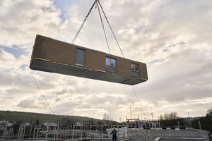 Einbringung eines zu über 90% vorgefertigten Holz-Hybrid-Raummoduls von Kleusberg mit hochwertigen Bauelementen sowie vorgehängter und hinterlüfteter Holzfassade. Vorteil: Die aus insgesamt 4 solchen Modulen bestehenden Wohngebäude sind jederzeit einfach und nahezu verlustfrei Demontierbar und an anderer Stelle erneut einsetzbar, auch für andere Zwecke.   