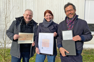  DBZ-Chefredakteur Michael Schuster (l.) übergabdie Siegprämie an Pascal Flammer (r.) und Rahel Leugger von  der Baugenossenschaft (M.)  