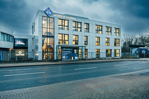  Links der Übergang zum Bestand und in der Bildmitte der Neubau für den Kochtechnik-Spezialisten MKN. Hinter der gerasterten Fassade befindet sich neben vielfältigen Arbeitsbereichen vor allem eine Showküche 