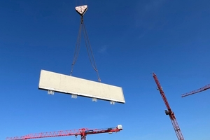  Effizient Bauen bedeutet bauzeitenflexibel: Schöck TELLIGENT® bietet Produktlösungen, die einen hohen Vorfertigungsgrad der Bauteile ermöglichen und damit just-in-time auf die Baustelle geliefert werden können. Im Bild: Ein Brüstungselement für die Attika mit Schöck Isokorb CXT Typ A wird per Kran eingehoben. 
 