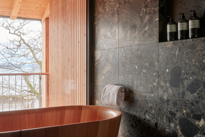 Eine Auswahl von Naturwerkstoffen, wie gebürs-tete Lärche und Fichte, Naturstein, Glas undMarmor, bestimmen die Architektur