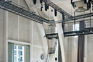  Der Schornsteinschacht sowie das Laufstegsystem erinnern an die ehemalige Nutzung des Gebäudes als Kesselhaus. Die großen Fenster an der Kurzseite dienen heute auch der Anlieferung 