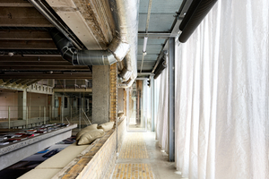  Wie im EG zur Straße hin wurden auch im 1. OG die sorgfältig entfernten Ziegel als Bodenbelag genutzt. Die alten Fensteröffnungen der Südfassade wurden an vielen Stellen belassen und fungieren als Raumtrenner 