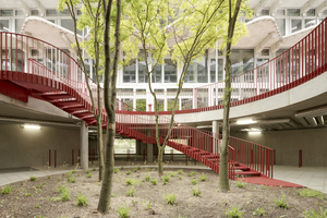 Das Sockelgeschoss ist mit dem Innenhof durch eine geschwungene Treppe verbunden. Die quer zum Raster gestellten Hausanschlussräume und Müllstellen steifen die Decke aus 