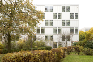  Der Blick auf die geschlossenere Südfassade mit den standardisierten Alu-Profilen. Das Gebäude bettet sich in eine von Grün geprägte Umgebung ein 