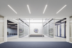  Der Innenhof im obersten Geschoss bietet das nötige Tageslicht am Arbeitsplatz und Kunst am Bau: Ein Portal in Bullaugenform von Sebastian Kuhn erzeugt durch Doppelspiegelung und Polarisationsfilter einen Lichttunnel und die Illusion unendlicher Räume 