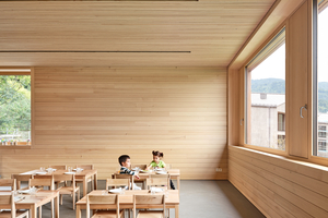  Die Holzoberflächen ziehen sich auch ins Innere des Gebäudes. Die horizontale Ausrichtung der Bekleidung unterstreicht das Raumkontinuum und bindet auch die Decke mit ein 
