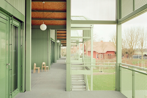  Auf den Laubengängen zeigt die Unterseite der überkragenden Dächer die unverkleidet verbauten OSB-Platten 