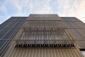  Mittig zur Straßenseite ergänzen goldene FlexForm® Profile die Fassade, in nach oben überlappenden Schichten.&nbsp; 