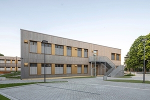 Die neue vierzügige Grundschule für 400 Kinder umfasst drei in vorgefertigter Holzmodulbauweise realisierte Lernhäuser, die sich um ein zentrales Aktionszentrum mit Mensa und Ganztagsbereich gruppieren.  