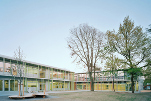  Links Schule, rechts eingegrabene Sporthalle mit Spieldeck oben drauf 