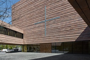  Die Gebäudehülle wurde in Rochlitzer Porphyr gemauert und gilt den Architekten als Bekenntnis zur Region und zur Tradition. Fällt Tageslicht durch das Kreuzfenster der Kirchenwand so wird das Zeichen im Kirchenraum entsprechend projiziert 