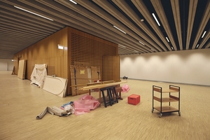  Blick in den Ausstellungsraum im UG. Der mit Eiche verkleidete Einbau beherbergt u. a. die Treppe, die sich als ganz eigener Raum bis nach oben fortsetzt 