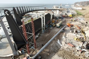  Der Mast wurde in Vorlage aufgestellt, um einen nahezu spannungsfreien Einbau der Hänger und Tragseile zu ermöglichen. Die Bügelböcke an den Abspannfundamenten wurden zunächst 600 mm über der Endlage aufgesetzt  