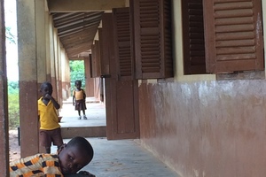  Erschließungsgang der Grundschule in Abetenim mit Kindern in gelb-brauner Schuluniform 