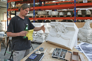  Bildhauermeister Andreas Klein neben einem kleinen Modell, das er von einer Wappenkartusche angefertigt hat 