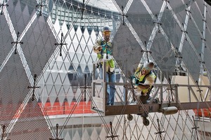  952 perforierte hochreflektierende Aluminiumpaneele hängen an dem gespannten Stahlnetz, das die Kontur der Kuppel nachzeichnet 