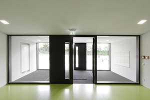 Eingang. Im Rücken das kleine aber gebäudehohe Foyer mit seiner skulpturalen, teils freitragenden Ortbetontreppe 