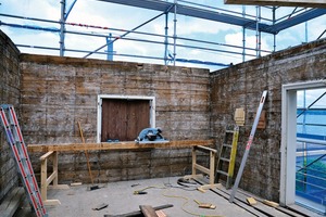  Bei den Abbrucharbeiten kam im Obergeschoss ein gut erhaltener Holzstrick zum Vorschein, der in aufwändiger Arbeit auf Sichtqualität gebürstet wurde. Der Strickbau, auch Blockbau genannt, war in der Region lange Zeit die bei traditionellen Bauernhäusern angewandte Bauweise. Die einzelnen Elemente mit einer Stärke von 12 – 18 cm wurden horizontal gestapelt, an den Ecken miteinander „verstrickt“ und mittels Holzzapfen verbunden. Die so entstandene steife Konstruktion konnte die auftretenden Kräfte gut aufnehmen und ableiten 