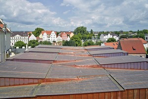  In der gefalteten Dachlandschaft finden sich die Zinnen und Türme der historischen Stadtmauer wieder. Das große Volumen der Baumasse fügt sich durch die bewegte Dachlandschaft harmonisch in die kleinteilige Parzellenstruktur der Altstadt ein 