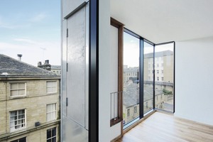  Aufgrund der Auskragung konnten Fenster über Eck realisiert werden, die hellere Räume schaffen und einen Blick entlang der Straße ermöglichen 