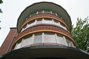  Eines der denkmalgeschützten Laubenganghäuser wurde mit einem WDVS mit Klinkerimitatoptik saniert, die runden Terrassen auf der Südseite mit Fenstern und einem auskragenden Dach geschlossen 