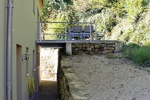  Über die Terrasse, die auf den wiederverwendeten Steinen des Gebäudes platziert ist, kann mit einer Rampe das obere Geschoss des Gebäudes in Zukunft barrierefrei erschlossen werden  