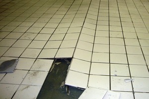  Schadensbild: Dachförmiges Aufstellen eines keramischen Belags auf einem Schwimmbadboden 