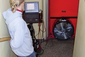  Drucktest mit Blower-Door vor der Sanierung: Sichtbar ist die rote Folie der Blower-Door mit dem eingebauten Gebläse und der Rechner zur Steuerung und Auswertung der Messung 